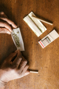 Person carefully rolling a cannabis joint in a relaxed setting