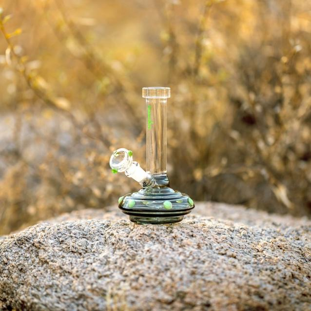 Clear glass water bong placed on a gray stone surface