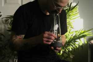 Person smoking cannabis from a water bong