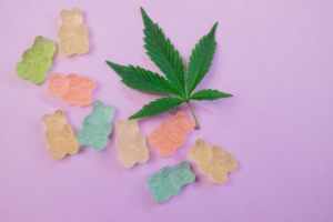 Cannabis gummies next to a cannabis leaf