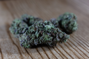 Dried cannabis buds on a wooden surface
