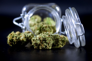 Cannabis buds spilling from a glass jar